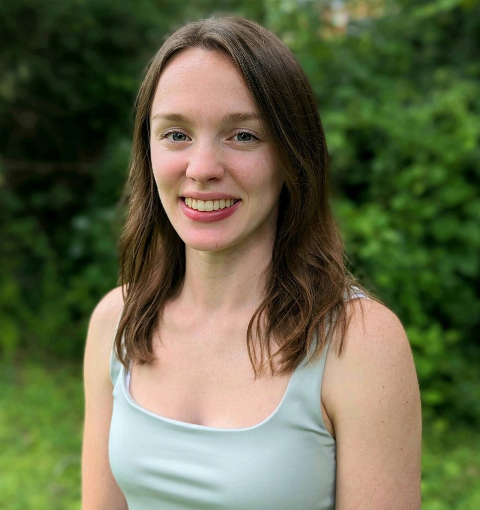 Outdoor photo of Liz Glasgo with shrubbery behind her